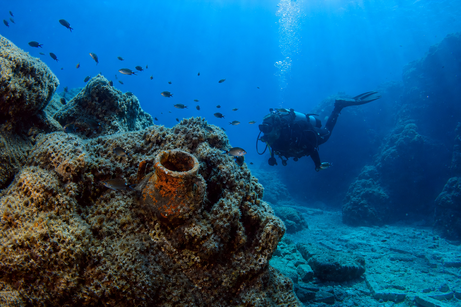 Scuba diver exploring a Greek island reef with clear blue water