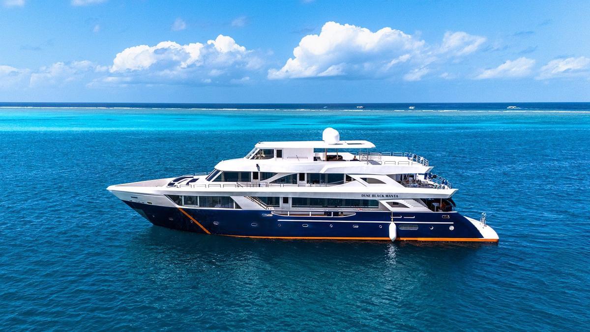 DUNE Black Manta liveaboard anchored over a coral reef in the Maldives
