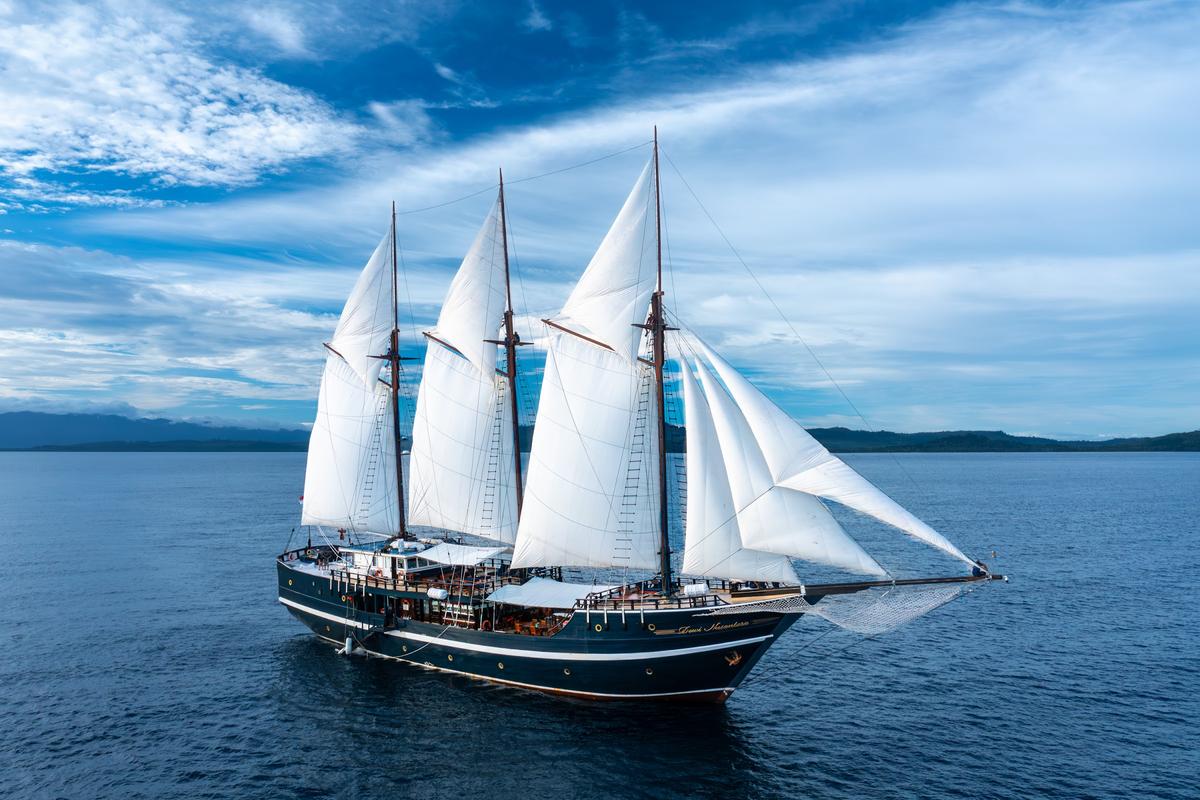 Phinisi liveaboard Dewi Nusantara under full sail off Indonesia